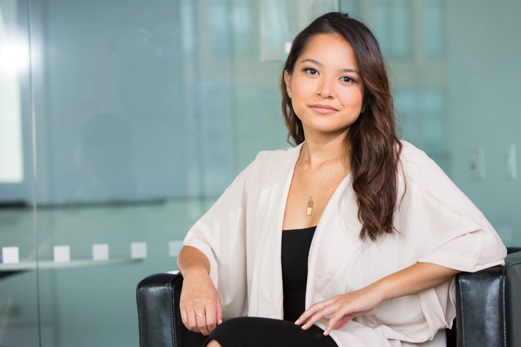 Light-skinned mixed-race young woman with long dark hair wearing a white shirt.